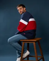 Buzo de felpa azul marino, rojo y blanco con diseño de bloques de color.