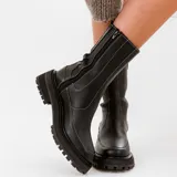 Bota corta tipo chelsea de cuero vacuno color negro, con suela de goma track, cierre lateral interno y elástico lateral externo.