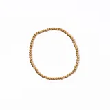 Pulsera elástica dorada con cuentas redondas.