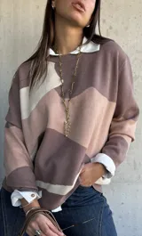 Sweater de punto con diseño de bloques de color en tonos tierra y beige, de corte oversize, cuello redondo y manga larga.