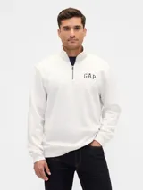 Buzo deportivo de hombre marca Gap, color blanco, con cuello alto y cierre frontal parcial. Presenta el logo de la marca bordado en el pecho.