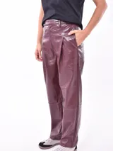 Pantalon de cuero sintetico color azul oscuro, de corte recto y tiro alto, con cintura con trabillas y cinturon incorporado con hebilla metalica dorada. Presenta bolsillos delanteros y costuras verticales decorativas.
