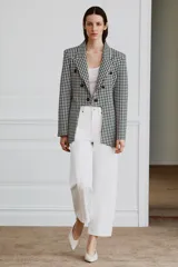 Blazer Zara Woman Collection de corte asimétrico con estampado de cuadros vichy en blanco y negro. Presenta cuello solapa, cierre frontal con botones y un diseño de bajo irregular con abertura central.