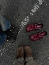 Zuecos de cuero marrón con diseño vintage, tachas plateadas y hebilla lateral.