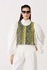 Top sin mangas confeccionado en cuero de oveja con estampado de piel de serpiente en tonos amarillo, azul y negro.