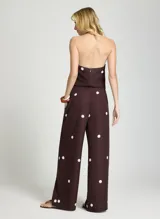 Pantalón de vestir marrón con estampado de lunares blancos, de tiro alto y corte ancho.