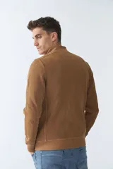 Campera negra de algodón con cierre completo, cuello alto, bolsillos laterales, puños y logo bordado en el pecho.