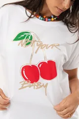 Remera blanca de algodón y elastano, con cuello redondo y mangas cortas. Estampado frontal con cerezas y texto en dorado.