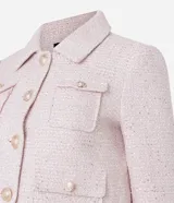 Campera corta de tweed color rosa, con cuello camisero, bolsillos delanteros con solapa y botones dorados estilo escudo.