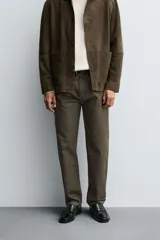 Pantalón de corte regular fit confeccionado en tejido ligero de algodón color marrón. Presenta diseño clásico de cinco bolsillos, cierre frontal con cremallera y botón metálico.