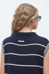 Vestido midi de punto azul marino con rayas horizontales blancas, sin mangas, con cuello polo y escote en V.