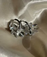 Aros tipo argolla con dije colgante en forma de flor realizado en acrílico transparente.