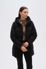 Campera acolchada color beige claro, de largo medio, con capucha y cierre frontal. Presenta costuras horizontales y diagonales que crean un efecto matelassé.