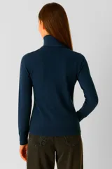 Polera de tejido de punto color blanco, con cuello redondo y manga larga.