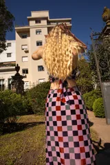Vestido largo de tul con estampado de cuadrados de terciopelo multicolor, cuello halter atado a la nuca y aberturas laterales en la cintura.