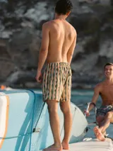 Short de baño color gris con estampado de palmeras, cintura elástica con cordón ajustable y tres bolsillos.