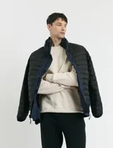 Campera 2 en 1 azul marino con capucha desmontable, cierre frontal con solapa de botones a presión y bolsillos laterales con cierre.
