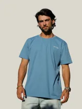 Remera blanca de manga corta con estampa en la espalda en color azul que incluye la frase 'Bo, hay pique!' y dibujos de peces y una caña de pescar.