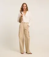 Pantalón de sarga color beige, de corte wide leg, con bolsillos cargo laterales y cintura alta.