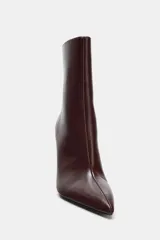 Botín de caña baja con acabado en punta y tacón alto fino. Presenta cierre mediante cremallera lateral.