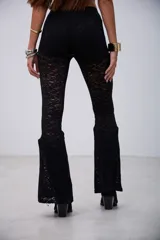 Pantalón de encaje negro, de corte ajustado en la parte superior y acampanado en la parte inferior.