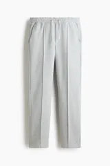 Pantalón tipo jogger de punto de peso medio con pliegue frontal cosido, cintura elástica con cordón de ajuste, bolsillos laterales y bolsillo trasero insertado.