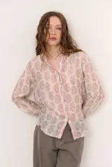 Camisa de manga larga con estampado estilo paisley, cuello en V y cierre frontal con botones y detalles en tono rosado.