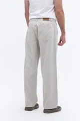 Pantalón de corte relajado y silueta amplia, confeccionado en algodón con acabado lavado. Presenta un diseño clásico de cinco bolsillos, cierre frontal con botón y costuras laterales reforzadas.