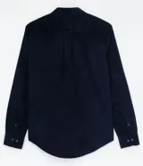 Camisa de manga larga confeccionada en terciopelo de algodón, con cuello clásico, cierre frontal de botones y bolsillo aplicado en el pecho.