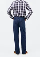 Pantalón de jean de corte slim, color azul clásico, con cierre de botón y cremallera, bolsillos laterales y traseros.