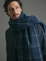 Bufanda de estilo escocés con textura, diseño clásico a cuadros y flecos en los extremos.