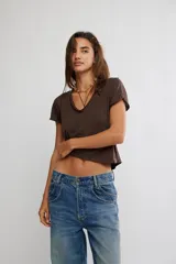Remera de jersey suave color negro, de calce relajado, corte recto y largo corto, con escote en V y mangas cortas caídas con puño fijado.