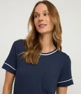 Camisón corto de manga corta y cuello redondo, color azul marino, con ribetes contrastantes en blanco en el cuello, mangas y bolsillo de parche en el pecho.