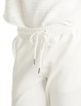 Jogger deportivo de corte holgado, con cintura elástica y lazo de ajuste, bolsillos laterales y puños elásticos en los tobillos.