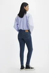 Jeans de tiro medio, color azul oscuro, de corte ajustado en cadera y muslos, y pierna skinny.