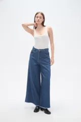 Pantalon de jean azul de corte ancho y tiro alto, con ruedo deshilachado.