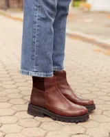 Botinetas de cuero color chocolate con diseño de paneles combinados en cuero liso y cuero texturizado. Presentan una suela track gruesa de goma negra y un corte tipo chelsea.
