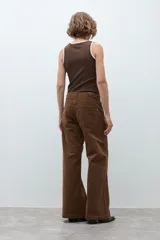 Pantalon de tiro medio y corte wide leg, confeccionado en pana color tostado. Presenta costuras verticales decorativas en el frente y bolsillos laterales.