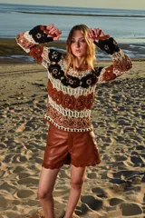 Musculosa tejida a crochet con diseño calado multicolor en tonos marrón, beige y negro.