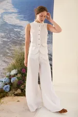 Pantalón de lino blanco de corte wide leg, con diseño amplio y costuras pespunteadas a contratono.