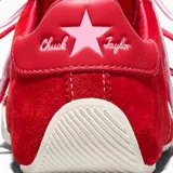 Championes Converse modelo Chuck Taylor Lo Pro, confeccionados en gamuza premium de color rojo con detalles en cuero al tono en el talón. Presentan puntera de goma reforzada, cordones en contraste y suela de goma con diseño texturizado.