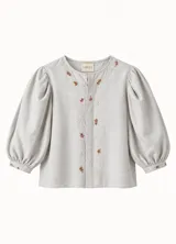 Blusa de lino color gris claro, de corte estructurado y diseño holgado, con mangas abullonadas tres cuartos y detalles bordados de hojas en el frente y cuello.