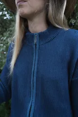 Campera tejida de punto con textura de rayas verticales, cierre frontal completo y cuello alto. Diseño de manga larga con hombros caídos.