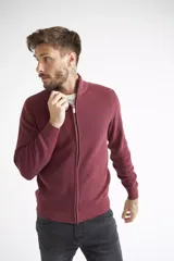 Campera tejida de algodón en color bordó, con cierre frontal completo, cuello levemente elevado y textura acanalada. Presenta puños y ruedo elásticos.