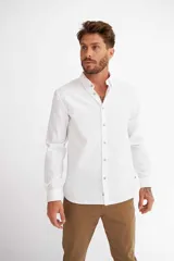 Camisa de manga larga con diseño de rayas verticales blancas y azules, cuello camisero y cierre frontal con botones.