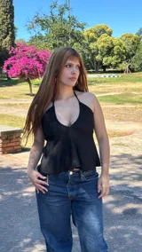 Top negro con escote halter, textura gofrada, detalle drapeado y nudo frontal, y corte fluido.