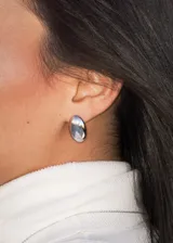 Aros colgantes de acero quirúrgico plateado, con forma ovalada y superficie lisa.