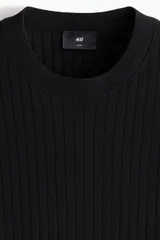 Remera de punto acanalado fino color negro, con cuello redondo y mangas cortas, de corte slim fit.