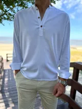 Camisola de lino blanca de manga larga con cuello mao y cierre frontal de botones.