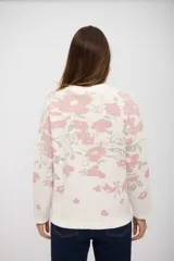 Buzo de tejido de punto con diseño estampado floral en tonos rosa y gris sobre base color crudo. Presenta cuello redondo y mangas largas con puños ajustados.